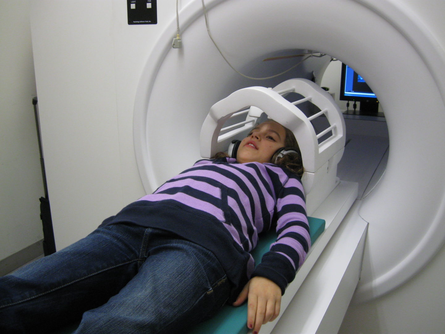 A young girl gets a brain scan inside an MRI machine